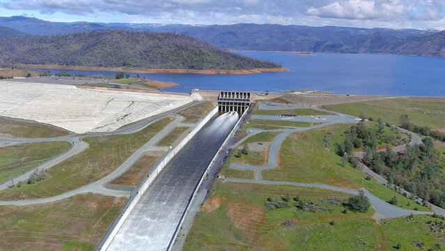 Lake Oroville Dam and spillway with cascading water dumping into the Feather River. 