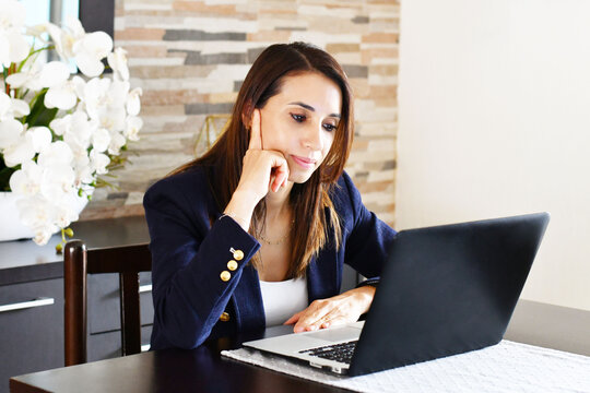 Mujer guatemalteca analizando resultados en su computadora, concepto de toma de decisiones gerenciales.