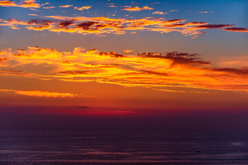 A lone boat in the waters of the Pacific Ocean off of the coast at San Diego California after sunset