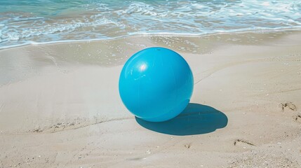 Obraz premium A minimalist image of a blue beach ball on a sunny, sandy beach