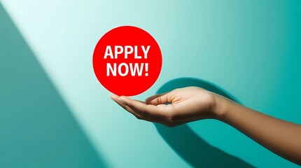 Hand Holding Red Circle with Apply Now Message on Turquoise Background Representing Job Application and Urgency
