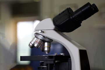 Compound Microscope focuses on the objective lens and body tube. It is a biology laboratory equipment used to magnify small objects into larger images.