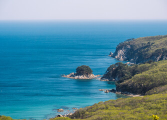 Serene view of rugged coastline and clear blue sea on a sunny day