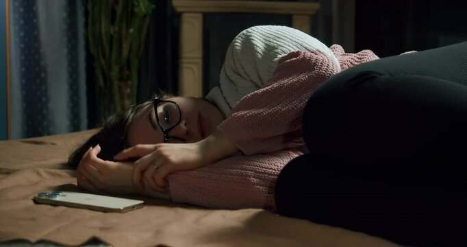 Teen girl in glasses texting with smartphone, highly emotional, crying. Teenage emotional, psychological problems concept. Bullying, cyberbullying, internet unpleasant, negative content.