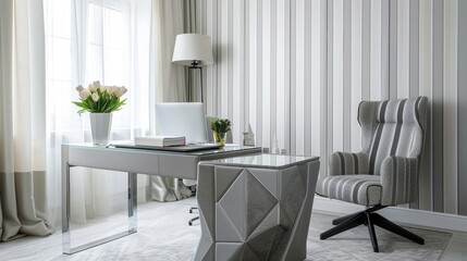 A contemporary office with white walls and a vertical striped wallpaper in shades of grey. The desk is a unique design with a grey geometric base and a glass top accompanied by a grey