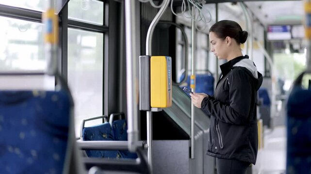 A woman pays with a card for travel on public transport. Concept of travel, trips and public movements.