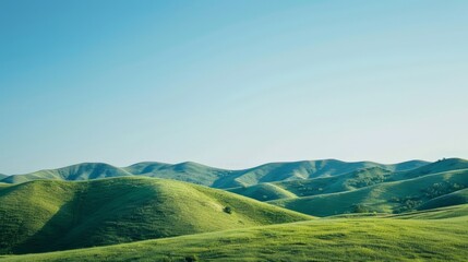 Obraz premium A serene landscape background featuring rolling hills under a clear blue sky, perfect for creating a peaceful and calming atmosphere.