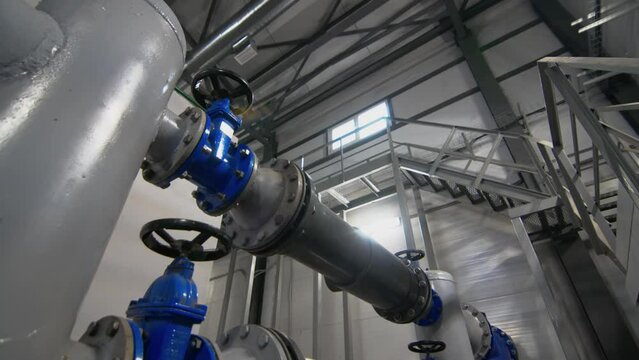 Pipework with valves to supply wastewater to tanks. Water head control system in workshop. Organization of equipment operation process
