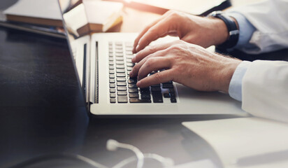 Medical, doctor and hands on laptop in hospital for research, wellness investigation or report for healthcare. Person, keyboard and typing for telehealth in clinic with internet, plan for surgery