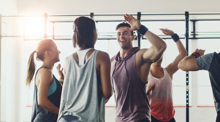 Fitness, high five or motivation and coach with students in gym for congratulations or support. Goals, success or target and personal trainer in celebration with class of people for exercise routine