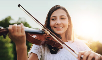 Face, smile and violin with girl in garden to practice for performance, recital or rehearsal. Art, instrument and music with happy child outdoor in backyard for creative, education or learning © Hira/peopleimages.com
