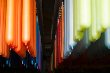 Rows of colourful candles hanging ready for sale