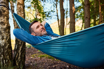 Carefree adult man relaxing in hammock
