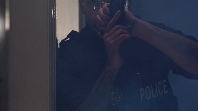 Zoom out police officer breaching a door in a raid slow motion