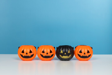 Halloween and decoration concept. Pumpkins orange and black on table with blue background. Jack o lantern pumpkin decoration on wooden table