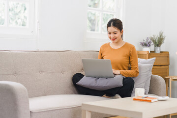 Happy asian young businesswoman calculate tax,counting paying domestic bills, e-banking, e-commerce, using laptop for calculation at home.