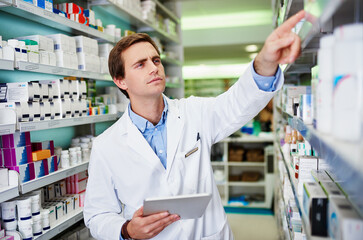 Inventory, tablet and thinking with pharmacist man checking stock of medicine on shelves for online...