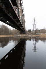 A beautiful springtime scene under the old metal railway bridge over the river. Metal construction from below.
