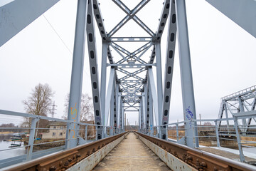 Close-up of the railway tracks over the metal truss bridge. Springtime scenery in Riga, Latvia.