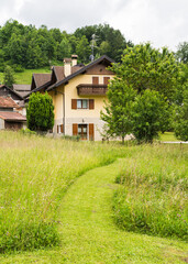 House and path on the grass in the mountains 