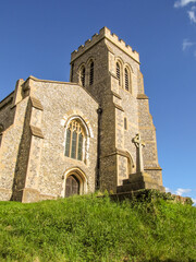 Looking up at the 15th Century Ellesborough church, on a small grassy hill, against a clear blue...
