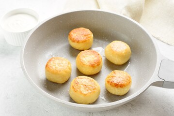 Cottage cheese pancakes (syrniki or curd fritters) in skillet