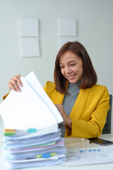 Female independent businesswoman, female office worker working with documents in the workplace Asian businesswoman sitting in modern office with documents and laptop computer.