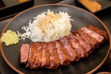 Set of Gyukatsu or beef cutlet served with cabbage. A traditional Japanese food that consists of a deep-fried beef cutlet.