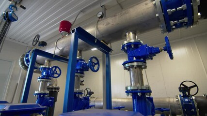 Water pumping system for tank filling with round valves for flow control. Liquid supply system to tanks in chemical plant workshop