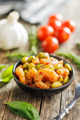 Fresh salad with shrimps and edamame soybeans in bowl on wooden table.