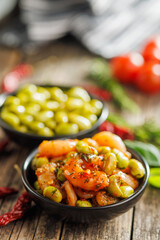 Fresh salad with shrimps and edamame soybeans in bowl on wooden table.
