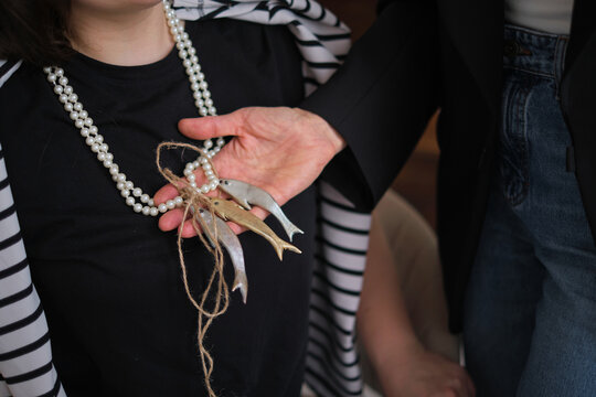 A stylist is showcasing a necklace to a seated client during a fashion consultation. The interaction highlights the personalized service and attention to detail in a contemporary, stylish setting.