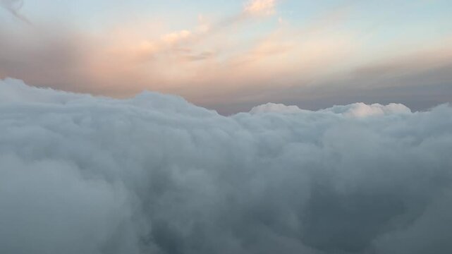 POV flying through a divine pastel color sky shot from an airplane cabin at sunrise. 4K 60FPS