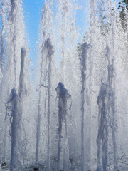Vertical fountain jets on a sunny day. Water texture.