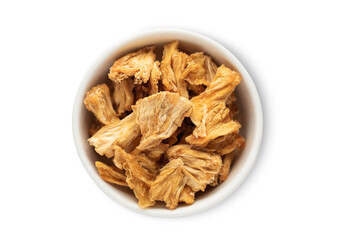 Ceramic bowl with sweet dried pineapple pieces isolated on white background.Top view.