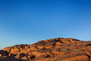 Scenic moon-like landscape of a rocky cliff and clear blue sky in Åland Islands, Finland, on a sunny evening in the summer. Off the beaten path in the nature. Copy space.