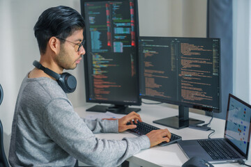 Asian man  prompt engineer develop coding app with software data sitting in front of computer monitor at office