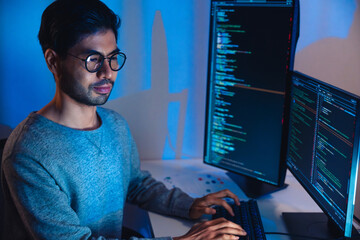 Indian software development working on coding  computer screen and flowchart at night in modern...