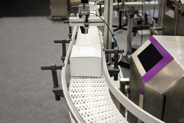 White cardboard box on the production line of a packaging and distribution machine.
