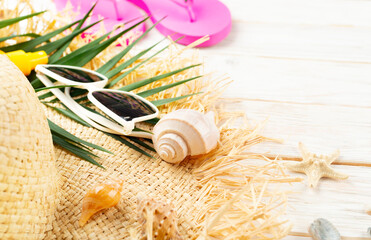 Vacation travel planning background of palm leaves, straw hat, sunglasses on white planks with copy-space