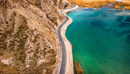 Aerial view of a winding driveway separating  mountains and lakes in Kuche Dalongchi in Xinjiang,...