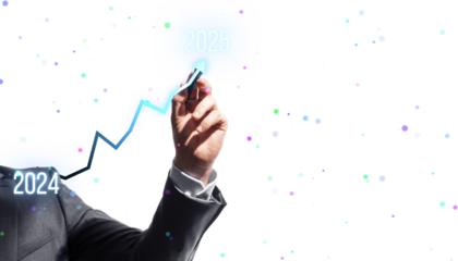 A person in a suit drawing an upward trend line labeled 2025 on a white background with colorful dots, symbolizing future growth