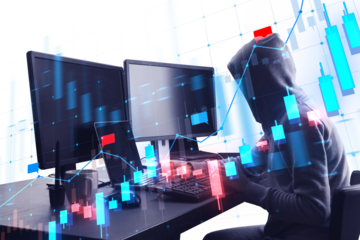 A person with a hood typing on a keyboard with graphic overlays of stock market data and trends on a blue themed background, concept of cyber security