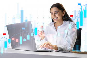 A businesswoman analyzing financial graphs on a transparent futuristic interface, with a laptop in front of her on a white background. Concept of modern finance analysis