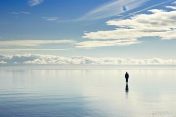 a lone person standing on the water in the middle of a lake