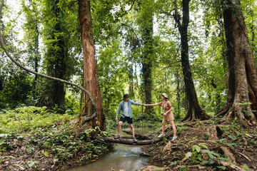 Happy young Asian couple hikers in nature together on vacation.