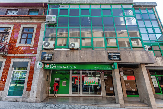 Vila Nova de Famalicao, Portugal - December 23, 2023: Credito Agricola bank agency. Client using the Multibanco aka ATM, on a Credito Agricola bank agency