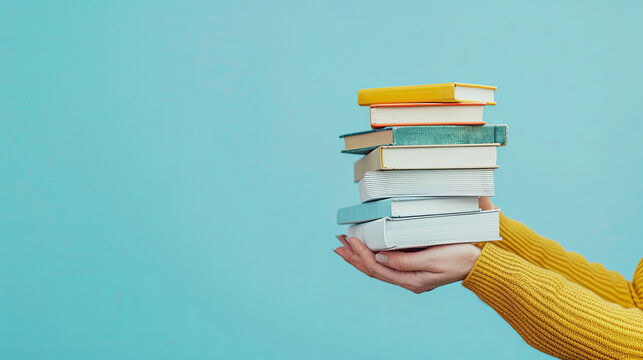 A stack of books is being held by a pair of female hands against a blue background, providing ample space for additional content or text