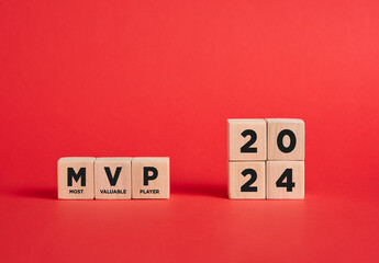 The abbreviation MVP most valuable player of the year 2024 on wooden cubes with red background. © Cagkan