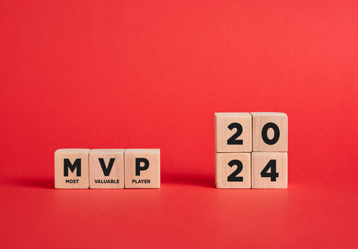 The abbreviation MVP most valuable player of the year 2024 on wooden cubes with red background.